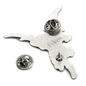 May include: Silver metal pin of a flying fairy with a silver butterfly on its back. The pin has a safety clasp on the back and the words "Hot Topic" are printed on the back.