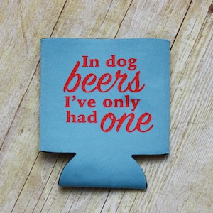 May include: A blue and red can cooler with the text "In dog beers I've only had one".