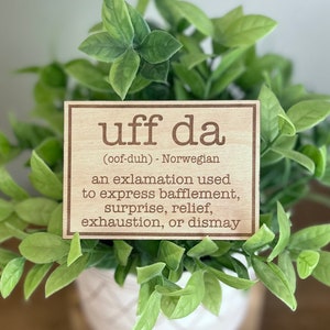 Peut inclure: Une pancarte en bois avec le mot norvégien "uff da" et sa traduction anglaise "(oof-duh)". La pancarte explique que "uff da" est une exclamation utilisée pour exprimer le décontenancement, la surprise, le soulagement, l'épuisement ou le désarroi.