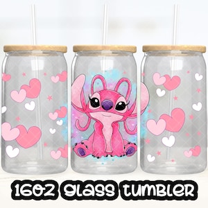 May include: Three 16oz glass tumblers with a pink and white heart pattern. The center tumbler features a pink cartoon character with blue eyes and a pink nose. The text "16oz glass tumbler" is printed below the tumblers.