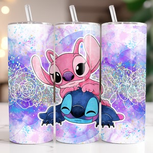 Op de afbeelding: Twee roestvrijstalen bekers met een roze en blauwe Stitch en Angel-ontwerp. De bekers hebben een aquarel achtergrond met glitter accenten.
