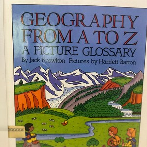 May include: A book cover with a colorful illustration of a mountain landscape. The title of the book is "Geography From A To Z A Picture Glossary" by Jack Knowlton and Harriett Barton.