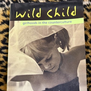 Może przedstawiać: Książka zatytułowana "Wild Child: Girlhoods in the Counterculture" z czarno-białym zdjęciem młodej dziewczyny w białym welonie na okładce. Książkę opracowała Chelsea Cain, a przedmowę napisał Moon Zappa.