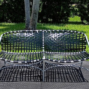 May include: A set of outdoor furniture consisting of a two-seat bench and two matching side tables. The bench and tables feature silver-toned metal frames and black woven strap seats and tabletops with a grid pattern design.