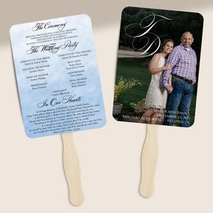 May include: Two wedding fans with wooden handles. One fan features a list of wedding party members and ceremony details against a blue watercolor background. The other fan has a photo of a couple and wedding details.