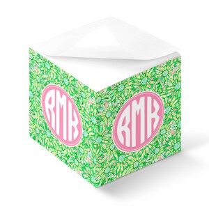 Könnte beinhalten: Ein grüner und weißer Notizblock mit floralem Muster und einem rosafarbenen Monogramm "RMK" auf der Vorderseite.