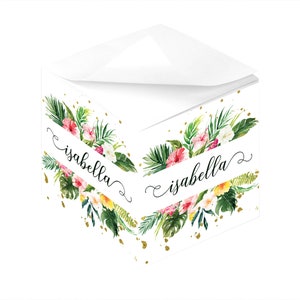 Könnte beinhalten: Ein weißer Notizblock mit floralem Design und goldenen Akzenten. Der Notizblock trägt den Namen "isabella" in Kursivschrift.