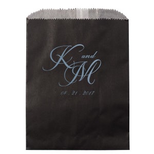 May include: Black paper gift bag with a blue and white monogram design that says "K and M" and the date "04.21.2017".