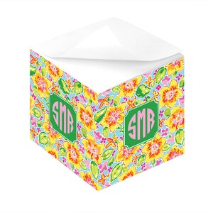 Könnte beinhalten: Ein Notizblock mit floralem Muster, grünem Rand und pinkfarbenem Monogramm "SMB" auf der Vorderseite. Der Notizblock ist in der Mitte gefaltet und die Oberseite ist offen.