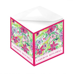 Könnte beinhalten: Ein Briefpapier-Set mit einem floralen Muster aus rosa Lilien, grünen Blättern und blauen Akzenten auf einem limettengrünen Hintergrund. Es hat einen leuchtend rosa Rand und den Text "CAMERON MITCHELL".