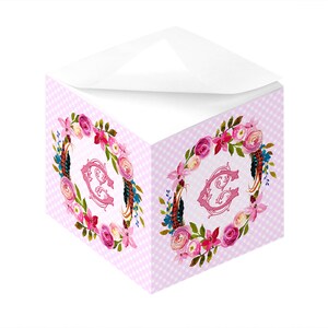 Könnte beinhalten: Rosaer Notizblock mit einem rosafarbenen Monogramm in Form des Buchstabens C in der Mitte eines Kranzes aus rosa Blüten. Der Notizblock hat ein rosa-weißes Karomuster.
