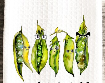 Puede incluir: Toalla de cocina blanca con una ilustración de acuarela de cinco vainas de guisantes verdes con caras de dibujos animados. El texto "STEAMED PEAS" está escrito en escritura negra debajo.