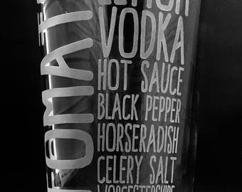Puede incluir: Un vaso de pinta transparente con texto grabado. La palabra "TOMATE" está grabada verticalmente en el lado izquierdo. Las palabras "LIMÓN, VODKA, SALSA PICANTE, PIMIENTA NEGRA, RÁBANO PICANTE, SAL DE APIO, WORCESTERSHIRE" están grabadas verticalmente a la derecha.