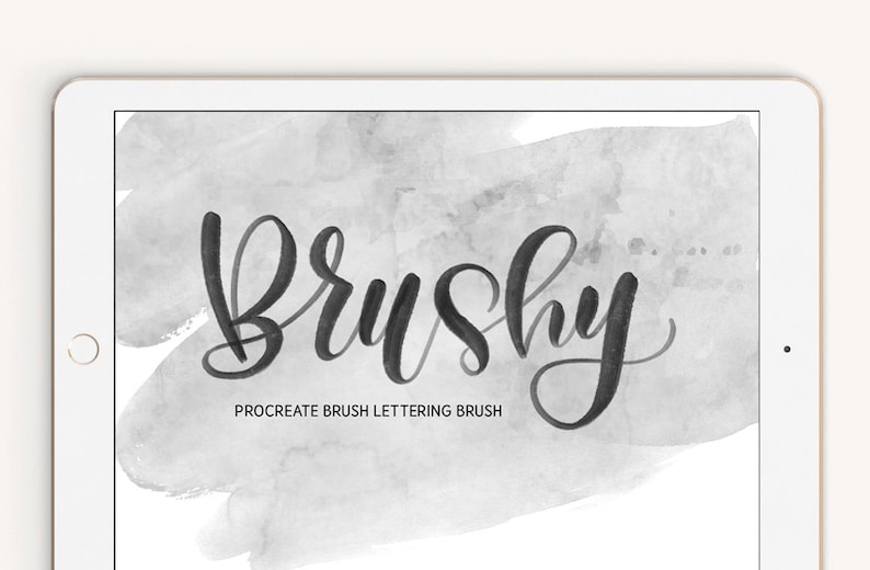 May include: A digital illustration of the word "Brushy" in a handwritten font on a gray watercolor background. The text below reads "Procreate Brush Lettering Brush".