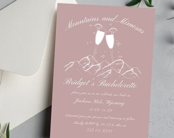 May include: A pink invitation card with white text that reads "Mountains and Mimosas" and "Bridget's Bachelorette". The card features a graphic of two champagne glasses with stars and mountains in the background.