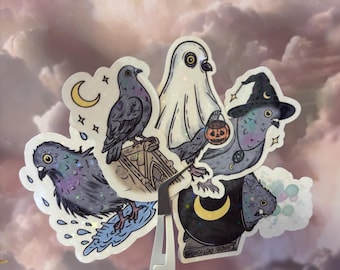 May include: A collection of die-cut vinyl stickers featuring various pigeon illustrations, including a pigeon on a ledge with a crescent moon, a ghost-costumed pigeon with a pumpkin bucket, a witch-hat-wearing pigeon, and a pigeon with a potion.