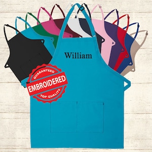 May include: A turquoise blue apron with two pockets and adjustable straps. The apron is embroidered with the name "William" and a red seal that says "Guaranteed Embroidered Top Quality".