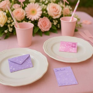 Puede incluir: Una mesa festiva con vasos, platos y servilletas de papel rosas. La mesa está decorada con un arreglo floral de rosas y margaritas rosas, recortes de hadas y pequeños sobres morados y rosas. Una nota dice "Querido amigo".