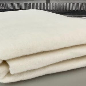Può includere: Un'imbottitura di cotone bianco piegata, un materiale morbido e soffice utilizzato per la trapunta e l'artigianato.