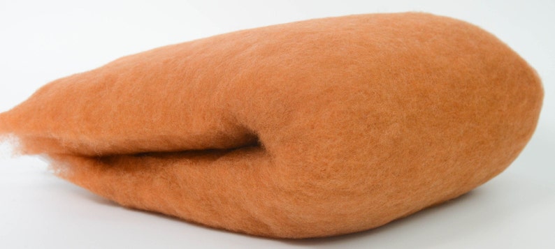 May include: A large amount of orange wool roving, a type of fiber used for spinning yarn or felting.