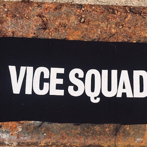 May include: A black fabric patch with white text that reads "VICE SQUAD".