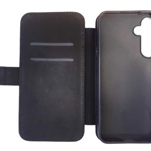 May include: Black leather phone case with a flap that folds over the screen. The case has a slot for cards on the inside.