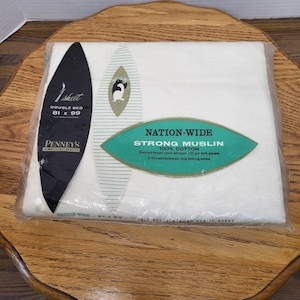 May include: A packaged white double bed sheet from Penney's. The packaging includes text that reads "Nation-Wide Strong Muslin 100% Cotton." The sheet measures 81 x 99 inches.