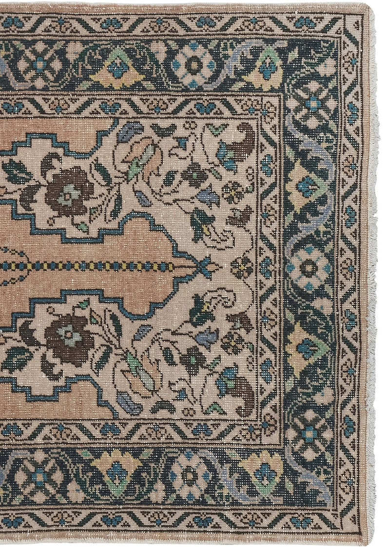 May include: A vintage rug with a beige background and a dark blue border. The rug features a floral pattern with intricate details.