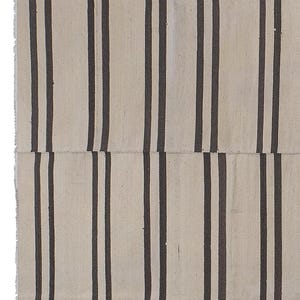 May include: A white and black striped rug with a woven texture. The rug is made of natural fibers and has a simple, minimalist design.