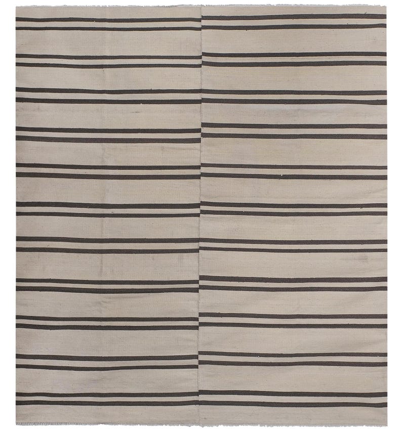 May include: A white and brown striped rug with a simple design. The rug is made of natural fibers and has a rustic look.