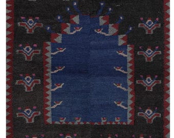 Peut inclure: Un petit tapis bleu foncé avec un motif géométrique. Le tapis a une bordure rouge et blanche et une frange.