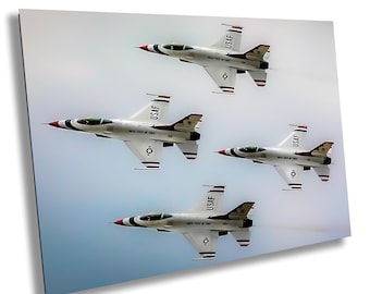 May include: Four white and gray USAF fighter jets in formation against a cloudy sky. Each jet has red, white, and blue accents on the nose and tail. The jets are angled slightly, creating a dynamic composition.