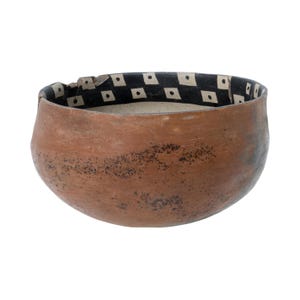 May include: A handmade, brown ceramic bowl with a rounded shape. The interior rim features a black band with white diamond-shaped patterns. The bowl's exterior has a textured, speckled appearance, and the interior is a light beige color.