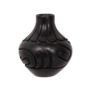 May include: Black ceramic vase with intricate geometric designs carved into the surface. The vase has a rounded body and a narrow neck.