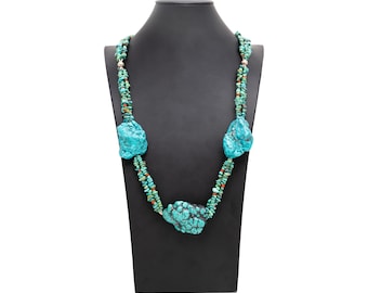May include: A turquoise necklace with large, irregular turquoise stones and smaller turquoise beads. The necklace is displayed on a black mannequin bust.