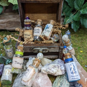 May include: A wooden treasure chest filled with small glass bottles containing colorful liquids and glitter. The bottles have labels with whimsical names like "Wizard's Magic", "Moon Dust", and "Butterfly Dreams".