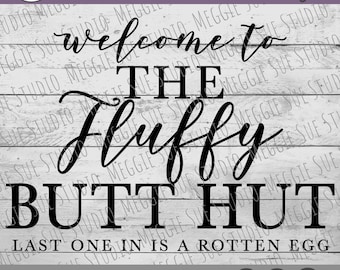 May include: Black and white text graphic on a wood background. The text reads "Welcome to The Fluffy Butt Hut. Last one in is a rotten egg."  The text is in a handwritten style font.