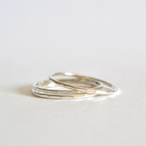 May include: Three silver stacking rings with a hammered texture.