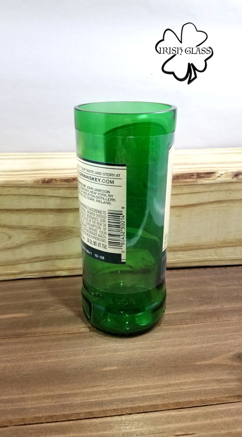 May include: A green glass bottle with a label that reads "Discover our taste and story at JohnJamesonWhiskey.com. Bottled by John Jameson & Son, Inc. New York, NY.  From the Midleton Distillery, Co. Cork, Ireland."