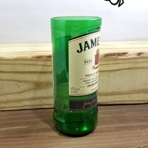 May include: A green glass bottle with a label that reads "JAMESON ESTD TRIPLE DISTILLED SMOOTH IRISH WHISKEY JOHN JAMESON & SON IRISH WHISKEY PRODUCT OF IRELAND John Jameson & Son"