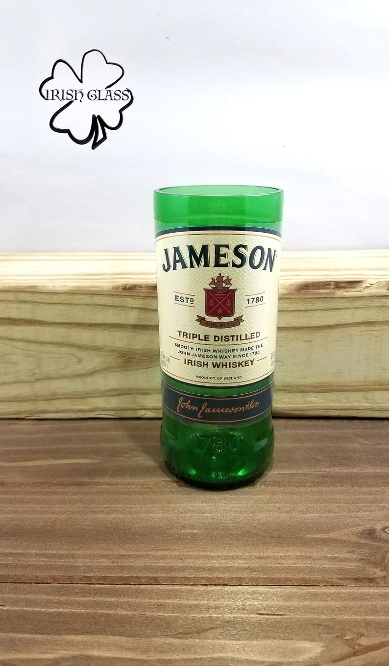 May include: A green glass Jameson Irish Whiskey bottle with a white label featuring the Jameson logo and the text "ESTD 1780", "TRIPLE DISTILLED", "SMOOTH IRISH WHISKEY MADE THE JOHN JAMESON WAY SINCE 1780", "IRISH WHISKEY", "PRODUCT OF IRELAND", and "John Jameson & Son".