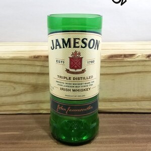 May include: A green glass with a Jameson Irish Whiskey label. The label features the Jameson logo, the words "Triple Distilled", "Smooth Irish Whiskey Made the John Jameson Way Since 1780", "Irish Whiskey", and "Product of Ireland".