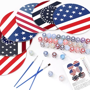 Può includere: Un kit di pittura numerata con tele circolari raffiguranti disegni della bandiera americana. Il kit include piccoli vasetti di vernice, pennelli e un foglio di riferimento. I colori sono rosso, bianco e blu. Le tele misurano circa 25 cm di diametro.