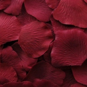 May include: A pile of deep red rose petals, perfect for scattering on a table or floor for a romantic occasion.