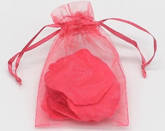 May include: A pink sheer organza bag with a drawstring closure, filled with pink rose petals.