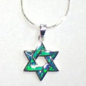 May include: A silver chain necklace with a green and blue opal Star of David pendant.
