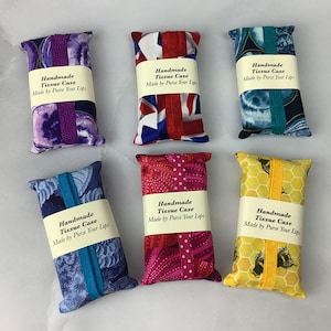 May include: Six handmade tissue cases with different fabric patterns. Each case has a label that reads "Handmade Tissue Case Made by Purse Your Lips".