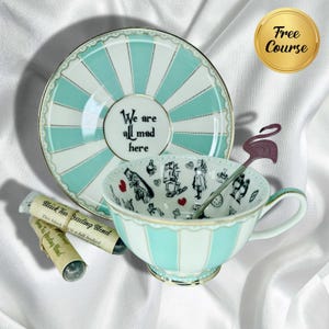 May include: A decorative tea set with a light blue and white striped teacup and saucer. The saucer has the text "We are all mad here." The teacup features Alice in Wonderland illustrations. Includes a flamingo spoon and tea samples.