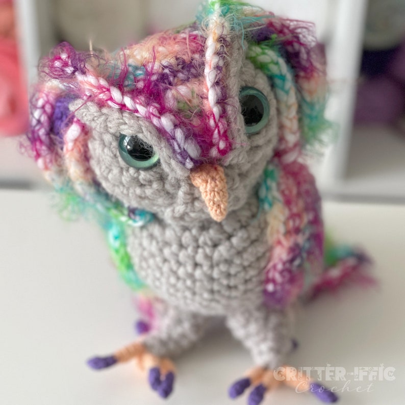 colorful crocheted screech owl sitting on a white table