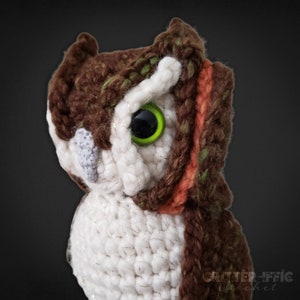 realistic crocheted brown screech owl close up in front of a black background